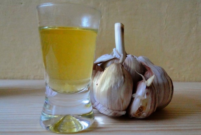 Чеснок и готовый стакан с чесночно-луковым отваром